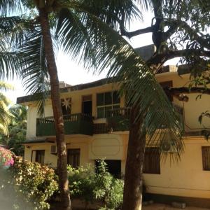 a house with two palm trees in front of it at J & B Holiday Homes in Benaulim