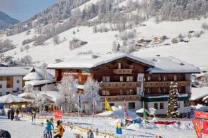 a large building with snow on top of it at Hotel Alpenland in Niederau