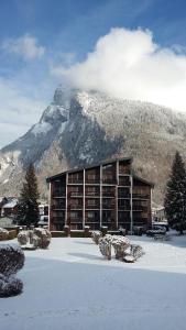 um edifício na neve com uma montanha ao fundo em Résidence "Rado" em Samoëns