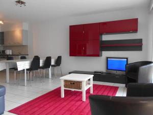 a living room with a tv and a table and chairs at Residentie Kompas 102 in Nieuwpoort