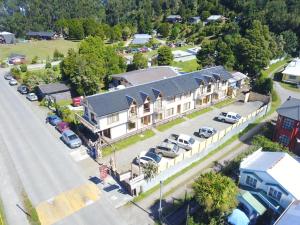 an aerial view of a large house with a parking lot at Hito Cero Apart Hotel in Quellón
