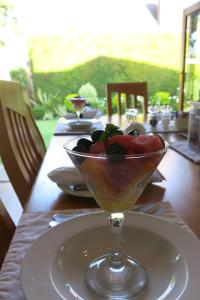 uma mesa com uma taça de fruta sobre uma mesa em Oakvale Lodge em Cidade do Cabo