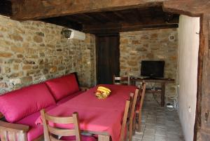 a living room with a red table and a couch at Къща Балканец in Balkanets