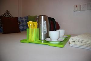 a tea kettle and cups on a green tray at Miheen Hotel & Resort - Anuradhapura in Mihintale