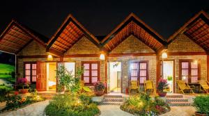 una casa con sillas y flores delante de ella en Tam Coc Cuong Hieu Homestay, en Ninh Binh