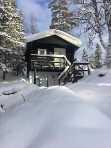 ein schneebedecktes Haus mit einem Schneehaufen in der Unterkunft Gilleråsvägen 13 C in Sälen