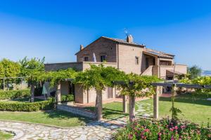 an external view of a house with trees and flowers at Villa delle Rose in Montalto delle Marche