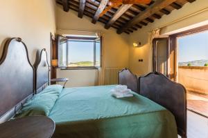 a bedroom with a bed with a green comforter at Villa delle Rose in Montalto delle Marche +35 photos