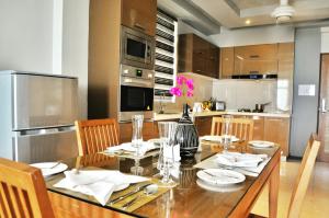 a kitchen with a wooden table with chairs and a dining room at Airport Comfort Inn Premium in Hulhumale