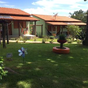 a yard with a house with a flower in the grass at Estancia Maria in Pirenópolis