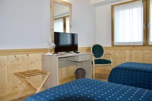 Zimmer mit einem TV, einem Bett und einem Stuhl in der Unterkunft SAN FERDINANDO in Levada