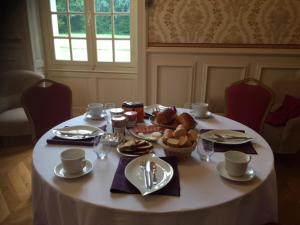 una mesa con un mantel blanco con comida. en Au Chateau de Montbraye, en Parigné-lʼÉvêque