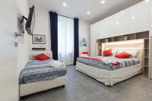 two beds in a bedroom with red pillows at La casa di Bicio in La Spezia