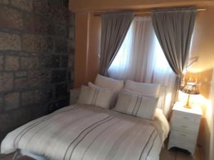 a bedroom with a white bed with a window at Die Ou Pastorie in Fouriesburg