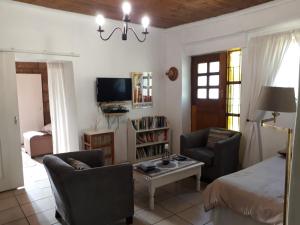 a living room with a bed and two chairs and a table at Die Ou Pastorie in Fouriesburg