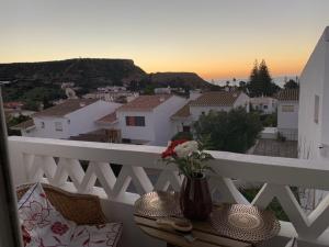 a vase of flowers on a table on a balcony at Luz Paradise in Luz
