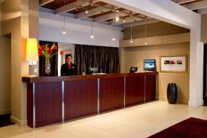 a man standing at a reception desk in a hotel lobby at The Ashley Hotel Greymouth in Greymouth