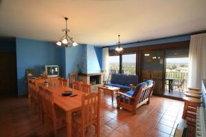 a dining room and living room with a table and chairs at La Premsa in Arnés