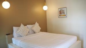 ein Schlafzimmer mit einem Bett mit Kissen darauf in der Unterkunft Sichon Modern House Hotel in Sichon