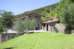 uma casa no lado de uma colina com um quintal em Villa Il Sole em Cortona