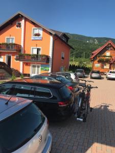 a bike parked next to cars in a parking lot at Plitvice Pension Perisic in Korenica
