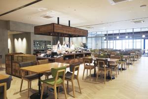 a restaurant with tables and chairs and a buffet at hotel MONday Premium TOYOSU in Tokyo