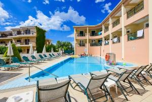 een zwembad met stoelen en een hotel bij Timos Hotel in Laganas