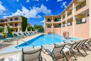 a swimming pool with chairs and a hotel at Timos Hotel in Laganas