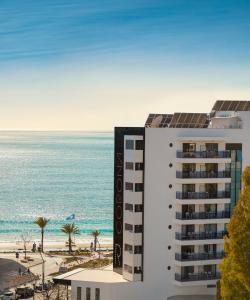 Una vista de un edificio y la playa. en Hotel RH Corona del Mar 4* Sup, en Benidorm