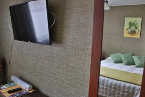 a mirror with a tv on a wall with a bed at Hostal Itaf in Arauco