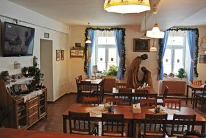 un comedor con mesas, sillas y ventanas en Restaurace a penzion Ubrousku prostři se, en Nová Bystřice