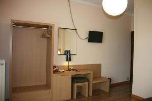 a room with a desk with a lamp and a mirror at Albergo Nardini in Lentate sul Seveso