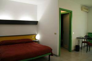 a bedroom with a bed and a table and a green door at Albergo Nardini in Lentate sul Seveso
