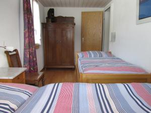 1 dormitorio con 2 camas y armario de madera en Gutenbrunnenstrasse 94, en Lenk