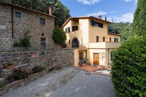 a large stone house with a stone wall at Villa Del Sole in Cortona