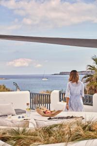 a woman standing on a balcony looking at the ocean at Parian Boutique Hotel in Naousa
