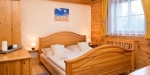 a bedroom with a wooden bed in a room at Penzion UNA in Liptovský Ján +108 photos
