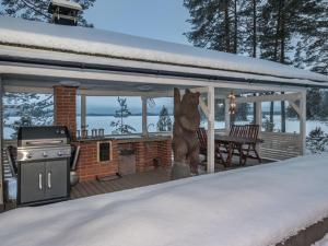 a statue of a bear standing on a deck in the snow at Holiday Home Villa helge by Interhome in Savitaipale
