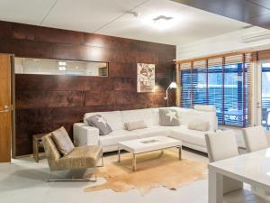 ein Wohnzimmer mit einem weißen Sofa und Stühlen in der Unterkunft Holiday Home Tahko spa suites orange a 4 by Interhome in Tahkovuori