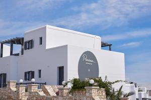 a white building with a sign on the side of it at Parian Boutique Hotel in Naousa