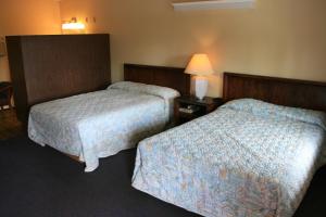 a hotel room with two beds and a lamp at Portland Value Inn & Suites in Portland