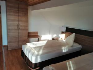 a bedroom with a large bed and a night stand at Grüner Baum in Langenau +3 photos
