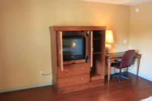 a room with a television and a desk and a chair at Portland Value Inn & Suites in Portland