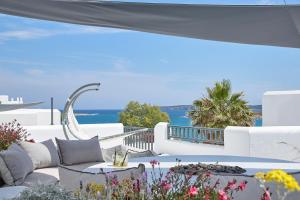 a patio with a couch and a table with a view of the ocean at Parian Boutique Hotel in Naousa
