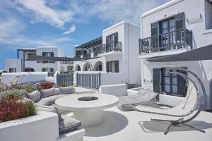 a white house with a patio with a table and chairs at Parian Boutique Hotel in Naousa