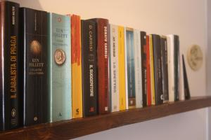 a row of books sitting on a shelf at Antica Fonte holiday home in Tavullia