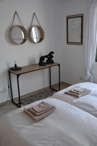 プラヤ・デル・イングレスにあるMASPALOMAS - Area Ciudadのベッドルーム1室(ベッド2台、鏡2つ付きのテーブル付)