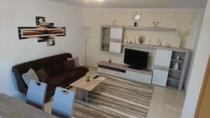 ein Wohnzimmer mit einem Sofa und einem TV in der Unterkunft Ferienwohnung Andreas in Herbolzheim