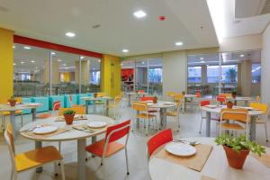 a restaurant with tables and chairs and colorful chairs at Apartamento no Olimpia Park Resort in Olímpia