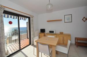a dining room with a table and a balcony at Apartamentos Zodiac in Lloret de Mar